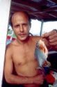 Brazillian fisherman holding a piranha on a riverboat on the Amazon River in Manaus Brazil.