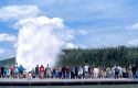 Tourists visit Old Faithful Geyser during eruption in Yellowstone National Park, Wyoming.
