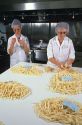 Women work in a french fry quality control lab.