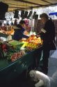 French man with his dog buys vegetables at a stand in Paris, France.