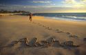 Aloha written in the sand on a Hawaiian beach.