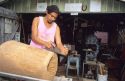 A hawaiian craftsman makes a drum from a coconut log on Big Island of Hawaii.