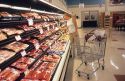 Woman shopping for meat in a grocery store.