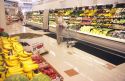 A woman shopping for produce in a grocery store.