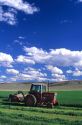 Farmer with tractor harvesting alfalfa hay in Malheur County, Oregon.