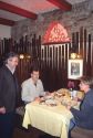 Owner chats with diners as they eat pasta in an Italian restaurant in Italy.