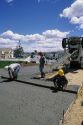 Workers pouring and screeding a concrete slab.