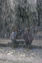 A couple sits behind a fountain in Frankfurt, Germany.