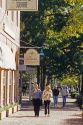 A couple walks along the sidewalk in the commercial area of colonial Williamsburg, Virginia.