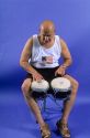 A man plays bongo drums.
