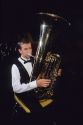 A teen playing an upright tuba.