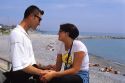 Young man and woman holding hands on the Italian Coast.