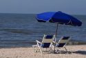 Gulf coast beach scene with chair and umbrella.