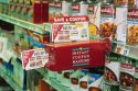 A supermarket coupon dispensing device sticks out in the aisle.
