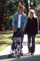 Parents walking their infant child in a stroller.  MODEL RELEASED