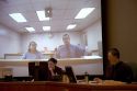 Video arraignment in criminal court in Boise, Idaho.  Defendants appear on video screen from secure jail facility while judge in courtroom conducts arraignment and sets bond.