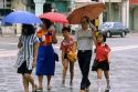 People in Singapore holding umbrellas in the rain.