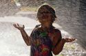 Six year old girl playing in a lawn sprinkler.