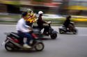 People riding scooters in Taipei, Taiwan.  Flower delivery man uses scooter.