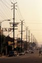 A Los Angeles street lined with cars and electric power lines, California.