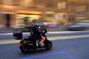 A woman rides a motor scooter in Rome, Italy.