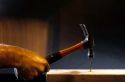 A hammer hitting a nail.