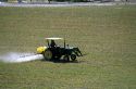 Tractor spraying herbicide on a field.