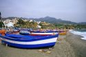 Beach scene with fishing boats in Nerja, Spain.