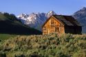 A log cabin and the Sawtooth Mountains in Stanley, Idaho.