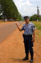 A police officer hitch hiking on the side of a road in Argentina.