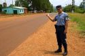 A police officer hitch hiking on the side of a road in Argentina.