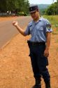 A police officer hitch hiking on the side of a road in Argentina.