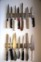 Kitchen knives displayed on magnetic strips.