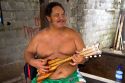 Tahitian man playing a ukelele with nylon strings in Papeete on the island of Tahiti.
