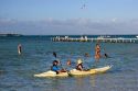 People swimming and kayaking in the lagoon at the Tipaniers Hotel on the island of Moorea.