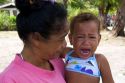Tahitian woman with a crying child on the island of Moorea.