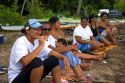 Local Tahitians at the beach on the island of Moorea watching canoe race.
