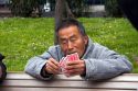 Asian man playing a game of cards in Chinatown, San Francisco, California.