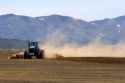 Farm tractor disking field in camas County, Idaho.