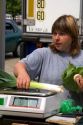 A woman weighs leeks at an open air market in Neuf-Brisach, France.