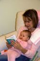 A mother reading a book to her infant child. MR