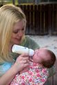 Mother feeding her newborn baby girl a bottle. MR