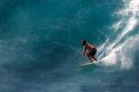 Surfing on waves in the pacific ocean off the island of Maui, Hawaii.