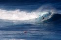 Surfing on waves in the pacific ocean off the island of Maui, Hawaii.