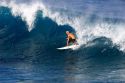 Surfing on waves in the pacific ocean off the island of Maui, Hawaii.