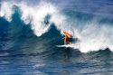 Surfing on waves in the pacific ocean off the island of Maui, Hawaii.