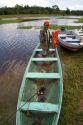Brazilian man in a dugout canoe on the Arasa River in the Amazon jungle near Manaus, Brazil.