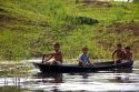 Brazilian boys in a dugout canoe on the Arasa River in the Amazon jungle near Manaus, Brazil.