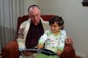 Grandfather reading to his granddaughter. MR