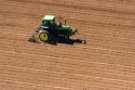 Aerial view of a farmer on a tractor spring tilling a field in Canyon County, Idaho.